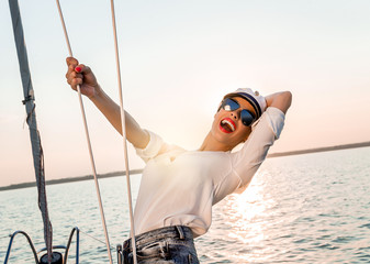 Adorable model wearing sea admirals hat and sexy top at sunset.