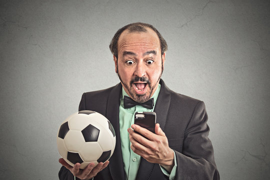 Man watching football game on smartphone excited face expression