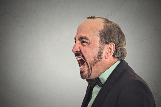 side profile portrait angry man screaming on grey background 
