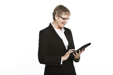 Senior businesswoman using tablet, studio