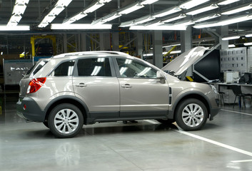 The new car with an open cowl costs in assembly shop. Automobile