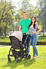 Young parents posing with their baby in a park