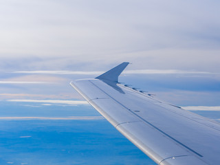 Wing of an airplane flying above the clouds.