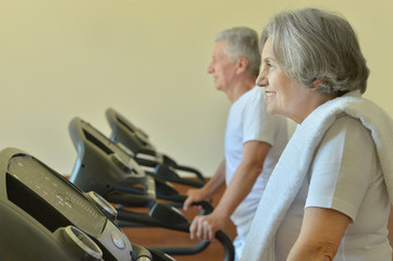 Elderly couple exercising in gym