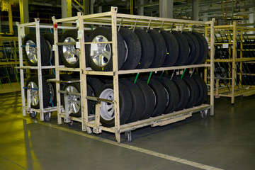 New automobile wheels lie on a rack in assembly shop of automobi