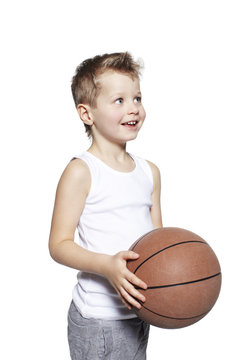 Young boy holding basketball, studio