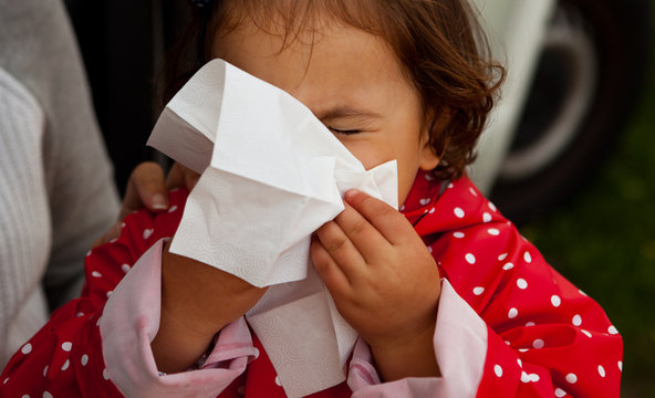 Baby girl blowing  for herself nose