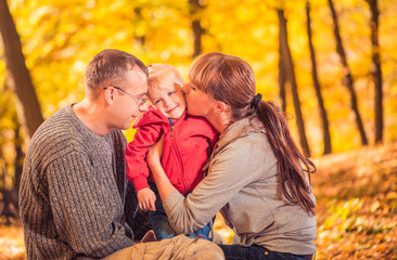 Fototapeta premium loveful family sharing kiss at fall forest