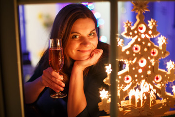 Portrait of young woman through window celebrating New Year's Ev