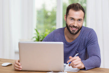 lächelnder mann arbeitet am laptop