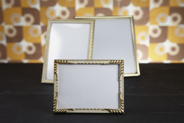 Blank picture frames against kitsch background