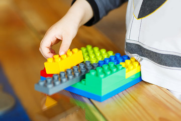 Hand child playing with construction blocks