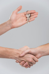 Two businessperson shaking hands on grey background.