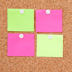 Blank sticky notes pinned on cork memo board