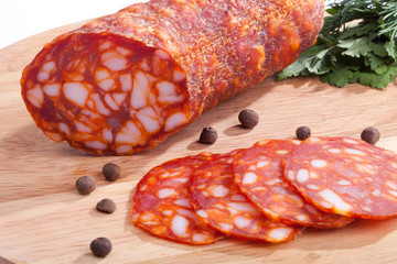 chorizo ​​sausage with herbs and pepper on the board