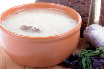 Fototapeta na wymiar soup kulesh of millet grains and meat with bread, garlic and her
