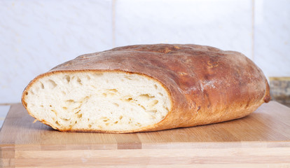 loaf of bread lying on a wooden board