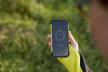 Female hand holding digital compass in the nature