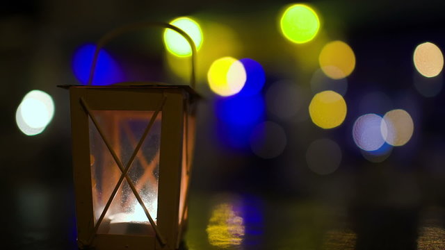 Outdoor lantern with candle inside stirring with wind