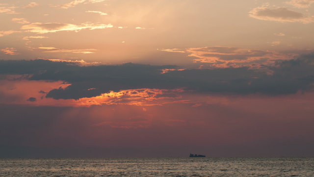 Timelapse of sunset over sea and sailing ship