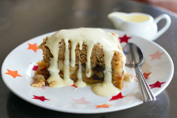 Slice of freshly baked apple crumble with cream