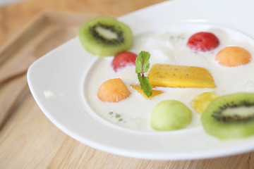 yogurt with fruit on wood background
