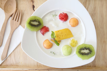 yogurt with fruit on wood background