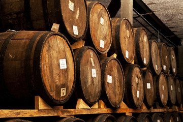 Wine barrels stacked in the old cellar of the winery.