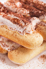 Tiramisu dessert strewed with cocoa on the white plate