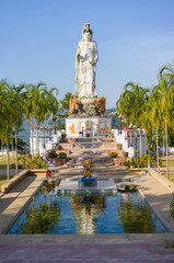 Fototapeta na wymiar Statue of Guan Yin / Kuan Im goddess and pool in front in Wat Ba