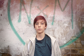 portrait of a teenage boy in front of a graffiti