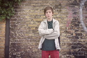 portrait of a serious teenage boy with crossed arms