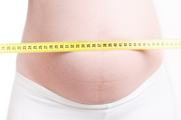 pregnant woman measuring belly