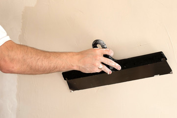 The process of applying a wide spatula second layer of putty