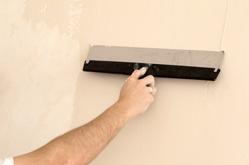 The process of applying a wide spatula second layer of putty