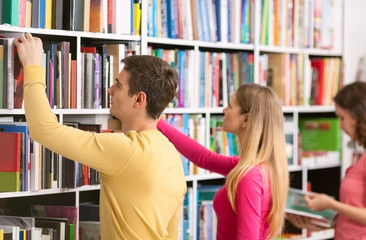 Three students looking for books 