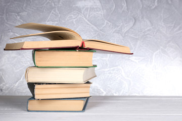Books on wooden table on light background