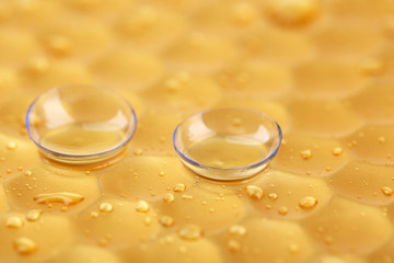 Contact lenses with water drops on bright background