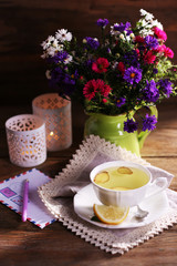 Still life of beautiful flowers in vase on wooden background