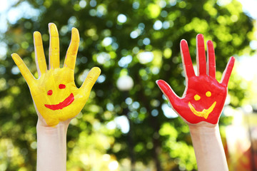 Smiling colorful hands on natural background