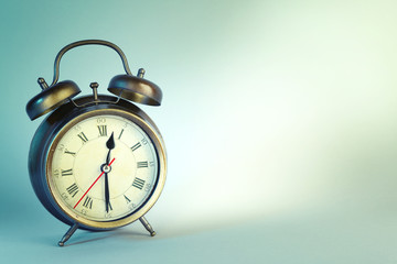 Old alarm clock on blue background