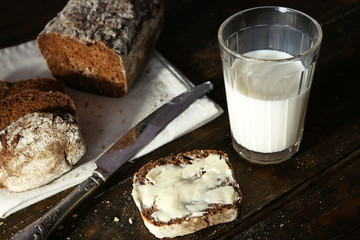 Sliced rye bread, glass of fresh milk and knife
