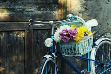 Vieux vélo avec des fleurs dans un panier en métal
