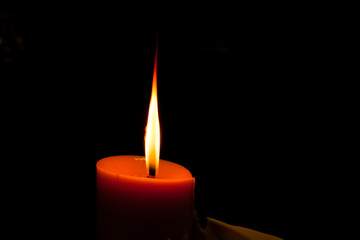 A burning candle in dark