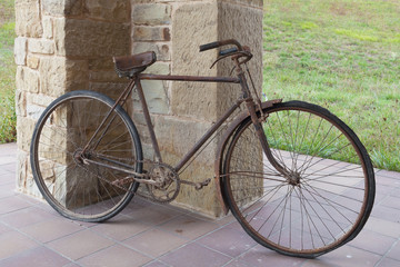 Naklejka na ściany i meble Antique or retro oxidized bicycle outside on a stone wall