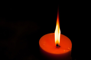 A burning candle in dark