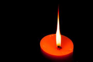 A burning candle in dark