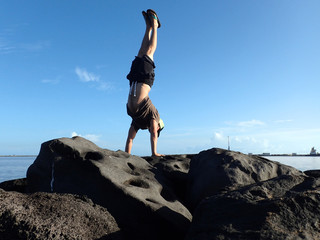 Man Handstands on rock jetty in Kahului Harbor