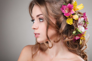 Beautiful girl with varicoloured flowers in hairs