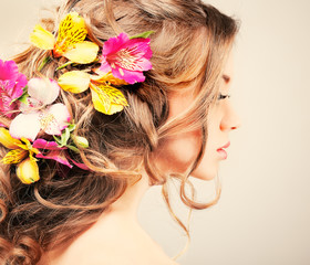Obraz na płótnie Canvas Beautiful girl with varicoloured flowers in hairs